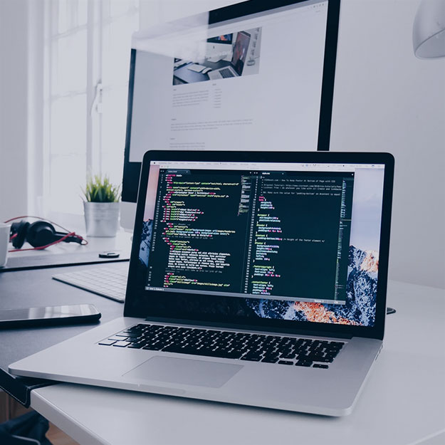 Laptop on a desk with code showing